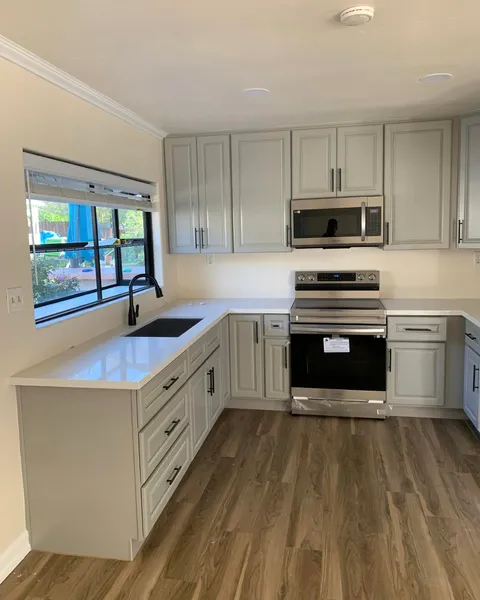 Remodeled San Diego kitchen with gray shaker cabinets, white quartz counters, and matte black fixtures