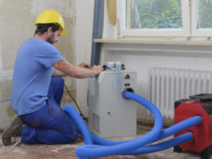 worker-adjusting-dehumidifier-in-an-apartment-whic-2022-12-16-22-40-30-utc