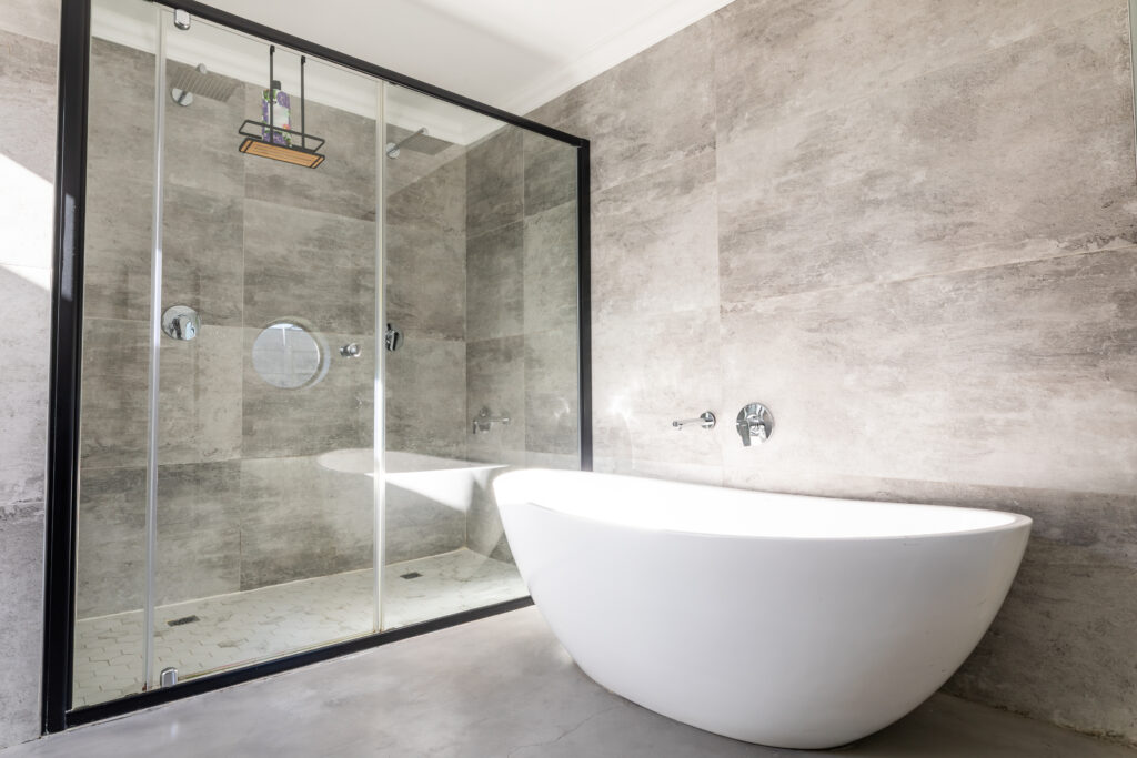 Empty bathtub by modern shower